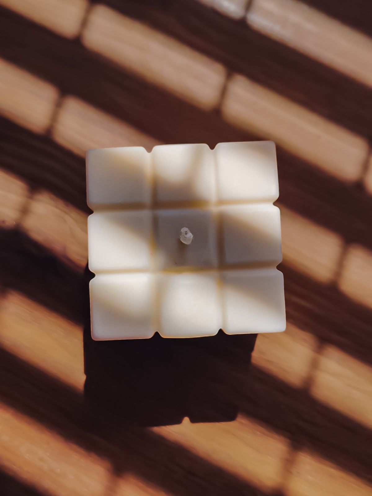bougie cube sur une table pour décorer son intérieur. bougie déco cube en cire naturelle.