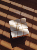 bougie cube sur une table pour décorer son intérieur. bougie déco cube en cire naturelle.
