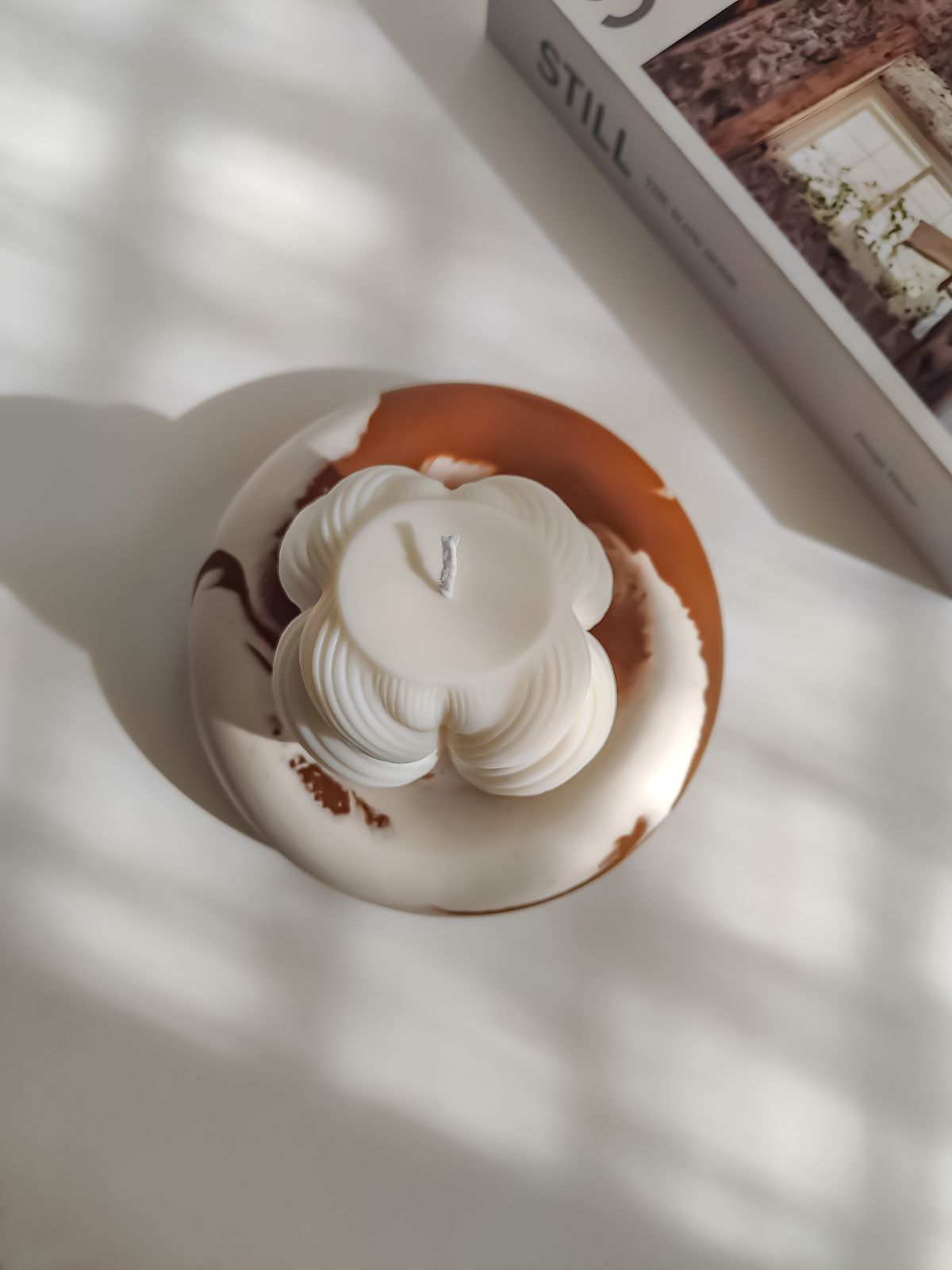 Bougie décorativeen forme de grande tresse sur un plateau rond. Tendance zen ou japandi pour un intérieur cosy et chaleureux. Bougie sculpturale fabriquée à la main en cire naturelle. Décoration moderne d'intérieur.